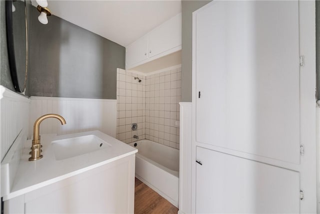 bathroom with tiled shower / bath combo, hardwood / wood-style floors, and sink