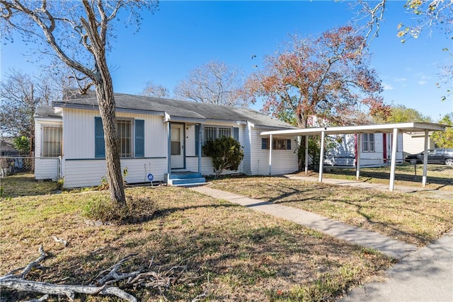 ranch-style house with a front yard and a carport