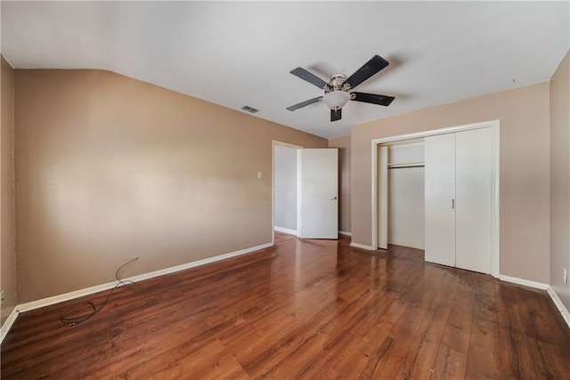 unfurnished bedroom with ceiling fan, dark wood-type flooring, a closet, and vaulted ceiling