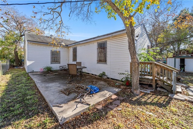 back of house featuring a storage unit and a patio