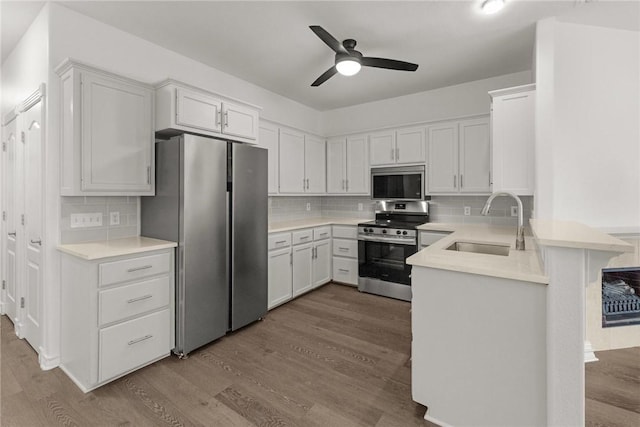 13901 Mingo Cay Ct Unit F, Corpus Christi, TX 78418 - kitchen with appliances with stainless steel finishes, a sink, a peninsula, ceiling fan, and dark wood-style flooring