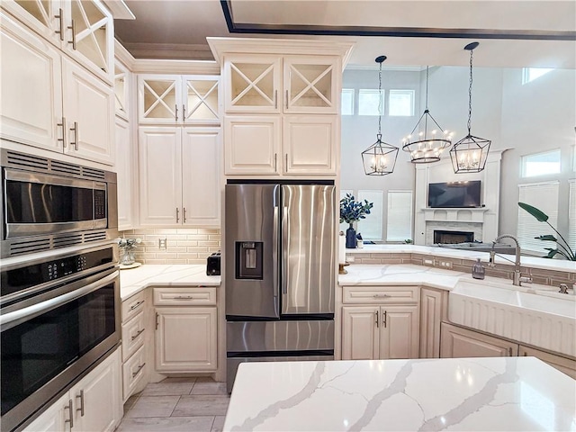 8137 Berenstain Dr, Corpus Christi, TX 78414 - kitchen featuring stainless steel appliances, a sink, decorative backsplash, glass insert cabinets, and a chandelier