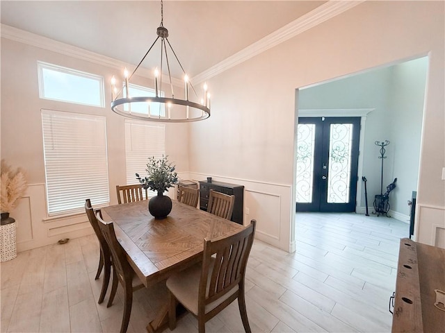 8137 Berenstain Dr, Corpus Christi, TX 78414 - dining room with crown molding, french doors, a chandelier, light wood finished floors, and a decorative wall