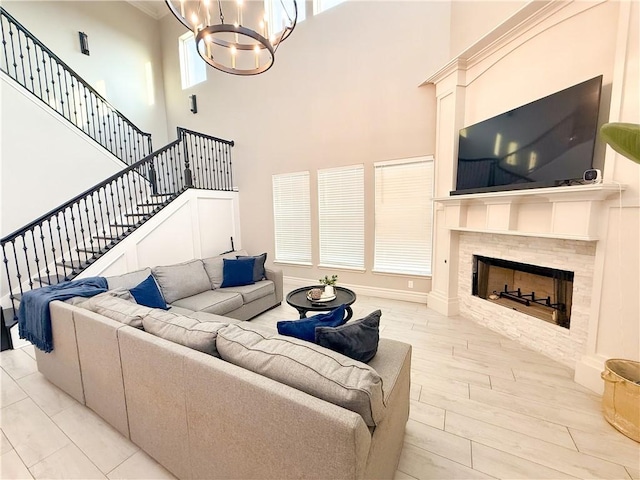 8137 Berenstain Dr, Corpus Christi, TX 78414 - living room featuring a towering ceiling, a chandelier, stairs, a tile fireplace, and wood finished floors