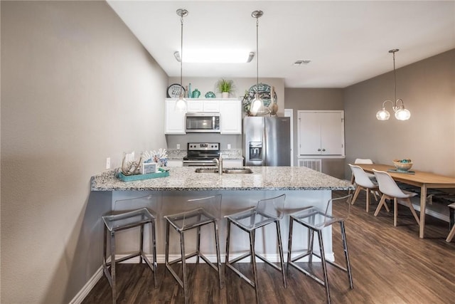 kitchen featuring stainless steel appliances, a peninsula, a sink, visible vents, and white cabinetry