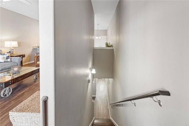 staircase with baseboards and wood finished floors