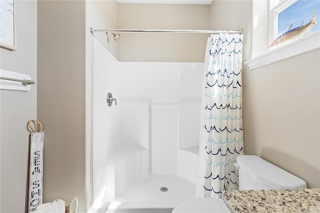 full bath featuring a shower with shower curtain and toilet