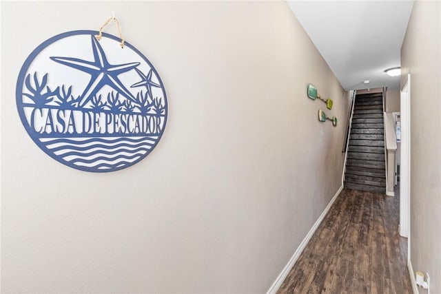 hall featuring stairs, baseboards, and wood finished floors