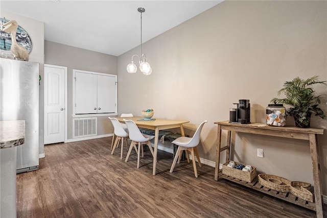 dining space featuring lofted ceiling, baseboards, visible vents, and wood finished floors