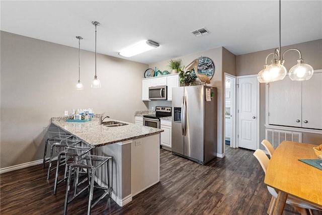 kitchen with visible vents, dark wood-type flooring, stainless steel appliances, white cabinetry, and a sink