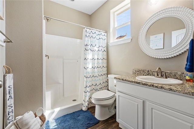 bathroom with toilet, a shower with curtain, wood finished floors, and vanity