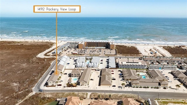 birds eye view of property with a water view and a beach view