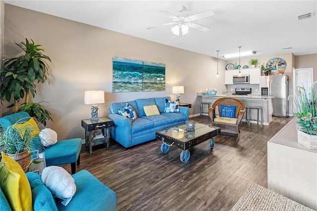 living area featuring a ceiling fan, baseboards, visible vents, and dark wood-type flooring