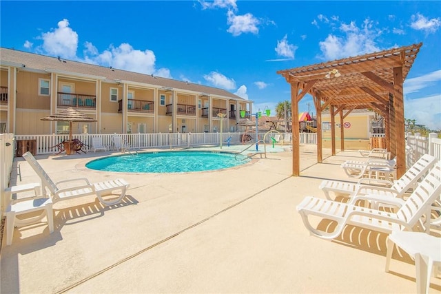 community pool featuring a patio area, fence, and a pergola