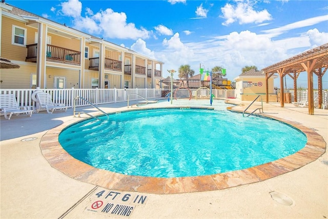 community pool with fence and a patio