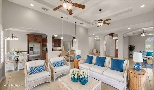 living area with arched walkways, light tile patterned floors, recessed lighting, a raised ceiling, and visible vents