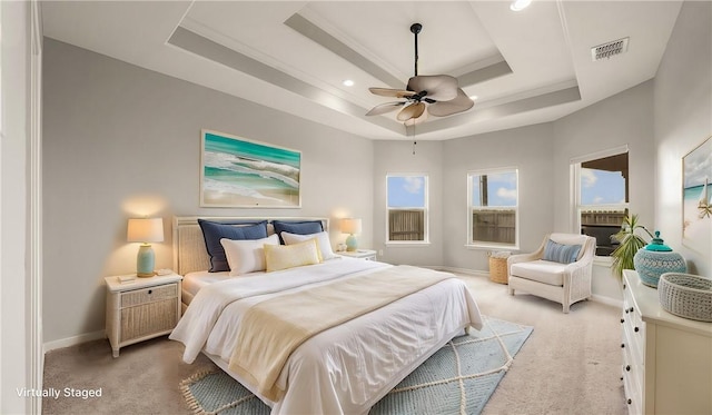 bedroom with baseboards, visible vents, a raised ceiling, and light colored carpet