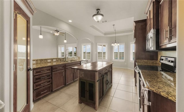 14149 Coquina Bay Ave, Corpus Christi, TX 78418 - kitchen with appliances with stainless steel finishes, a sink, ceiling fan, decorative light fixtures, and light tile patterned floors
