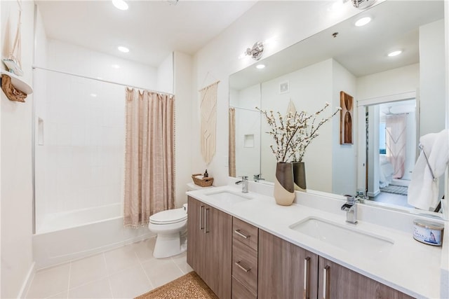 bathroom featuring tile patterned floors, toilet, double vanity, and a sink