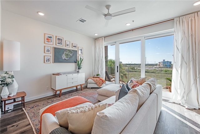 living room with dark wood-type flooring and ceiling fan