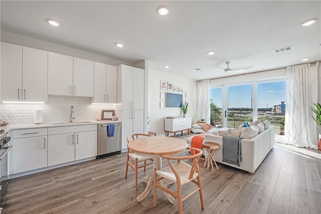 kitchen featuring white cabinetry, light wood-type flooring, sink, dishwasher, and ceiling fan