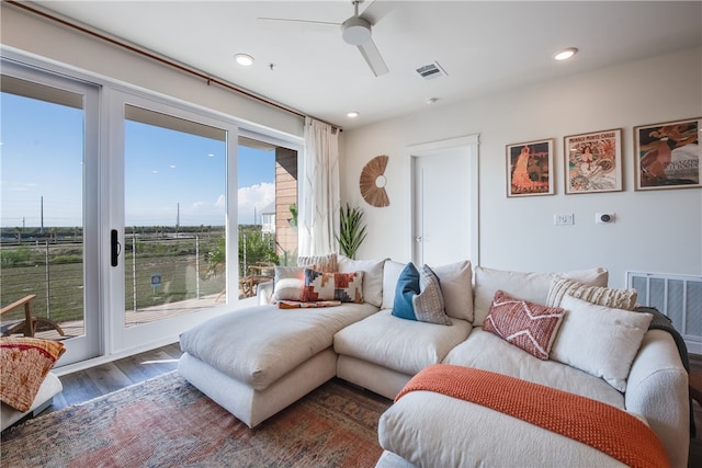 living room with dark wood-type flooring and ceiling fan