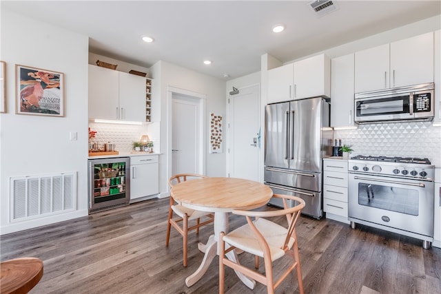 kitchen featuring white cabinetry, dark hardwood / wood-style floors, high end appliances, backsplash, and beverage cooler