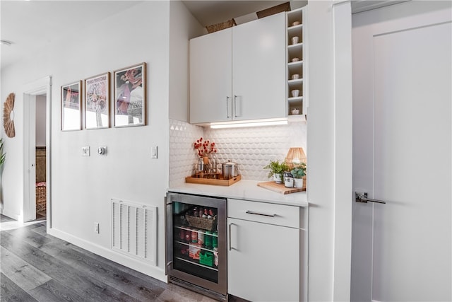 bar with wine cooler, white cabinetry, decorative backsplash, and dark hardwood / wood-style floors