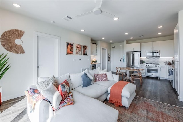 living room featuring dark wood-type flooring, ceiling fan, and recessed lighting