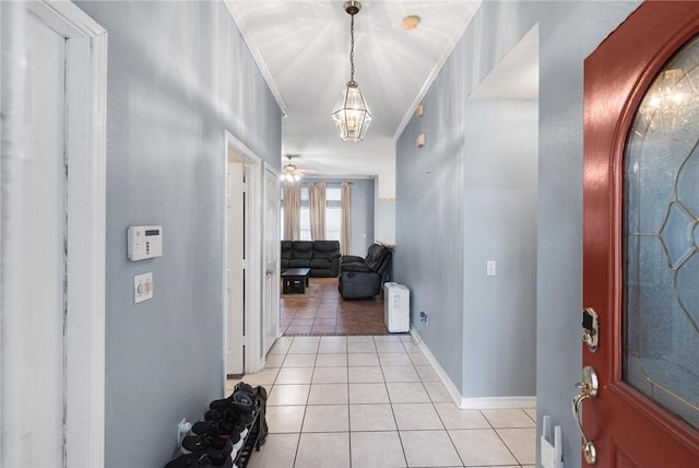 tiled entryway featuring ornamental molding and ceiling fan