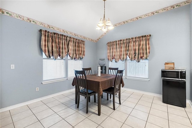 tiled dining space featuring a chandelier and vaulted ceiling