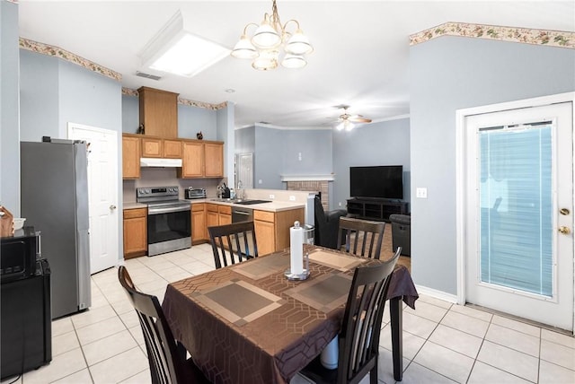 dining room with light tile patterned flooring, sink, ceiling fan with notable chandelier, and vaulted ceiling