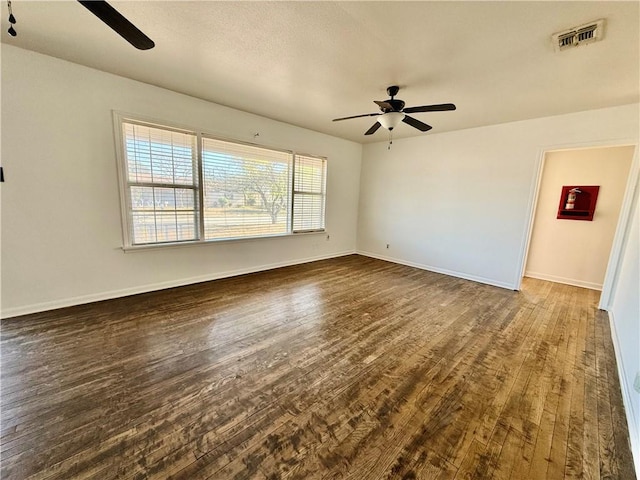 unfurnished room featuring ceiling fan and dark wood-type flooring