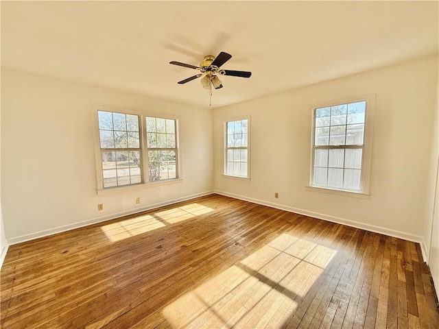 empty room with ceiling fan and hardwood / wood-style floors