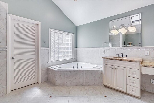 209 Jackson Pl, Corpus Christi, TX 78411 - bathroom with vanity, a bath, lofted ceiling, tile patterned flooring, and tile walls