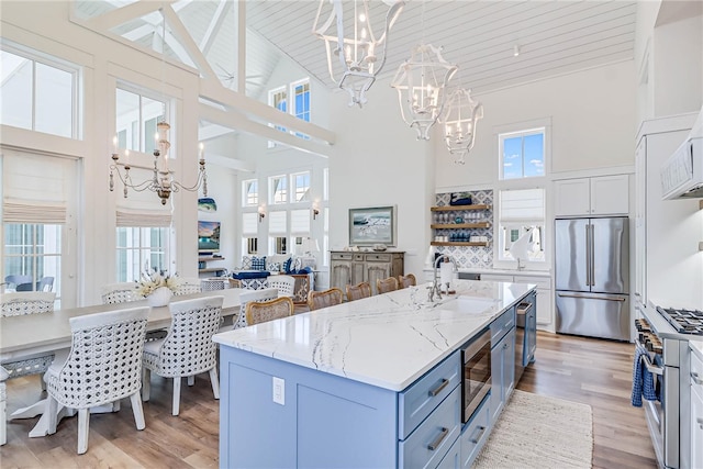 320 Coastline Dr, Port Aransas, TX 78373 - kitchen featuring a chandelier, high quality appliances, a sink, high vaulted ceiling, and light wood-style flooring