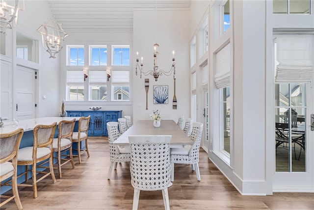 320 Coastline Dr, Port Aransas, TX 78373 - dining room with a chandelier, plenty of natural light, wood finished floors, and a towering ceiling