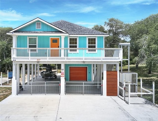 607 Huisache Lane, Ingleside On The Bay, TX 78362 - coastal home featuring a carport, concrete driveway, a shingled roof, and board and batten siding