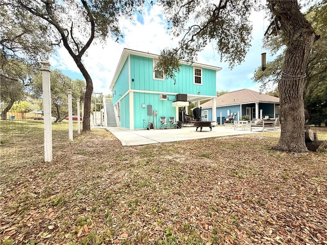 607 Huisache Lane, Ingleside On The Bay, TX 78362 - back of property with a patio, stairs, and board and batten siding
