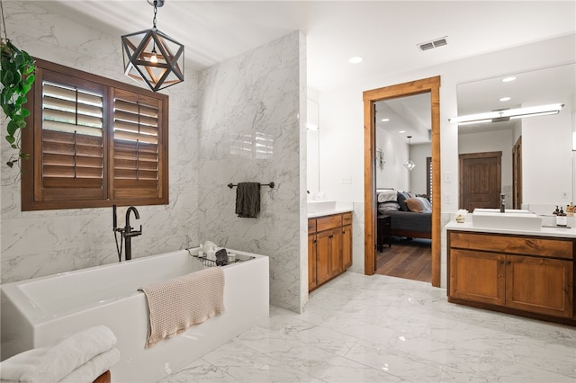 5502 E Riverview Dr, Corpus Christi, TX 78410 - ensuite bathroom featuring vanity, a freestanding bath, marble tiled flooring, tile walls, and recessed lighting