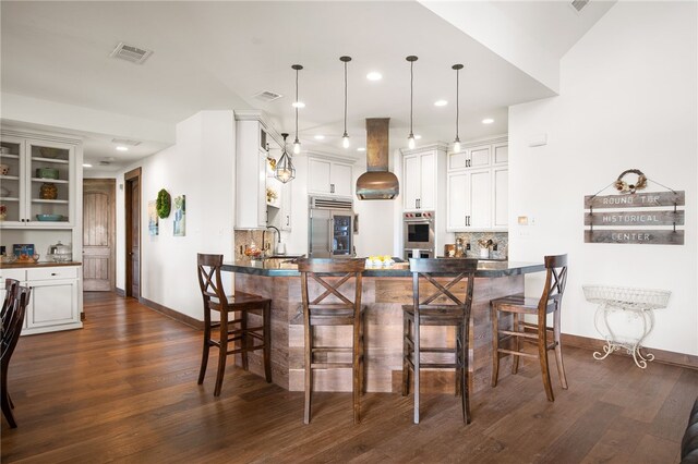 5502 E Riverview Dr, Corpus Christi, TX 78410 - kitchen with built in refrigerator, dark countertops, dark wood-type flooring, a peninsula, and recessed lighting