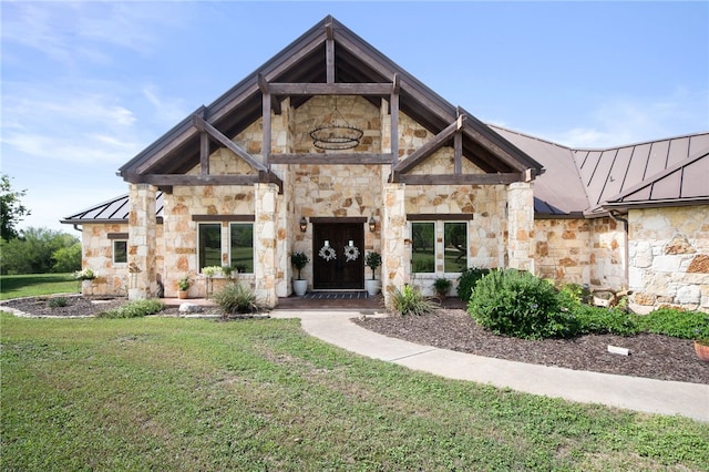 5502 E Riverview Dr, Corpus Christi, TX 78410 - view of front of home featuring a standing seam roof, stone siding, a metal roof, and a front lawn