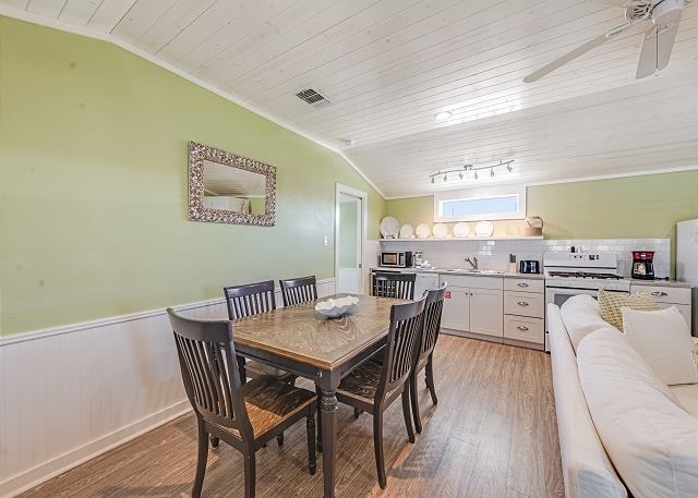 dining space with sink, vaulted ceiling, hardwood / wood-style flooring, and ceiling fan