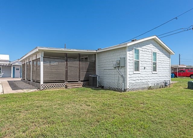 back of house with a lawn and cooling unit