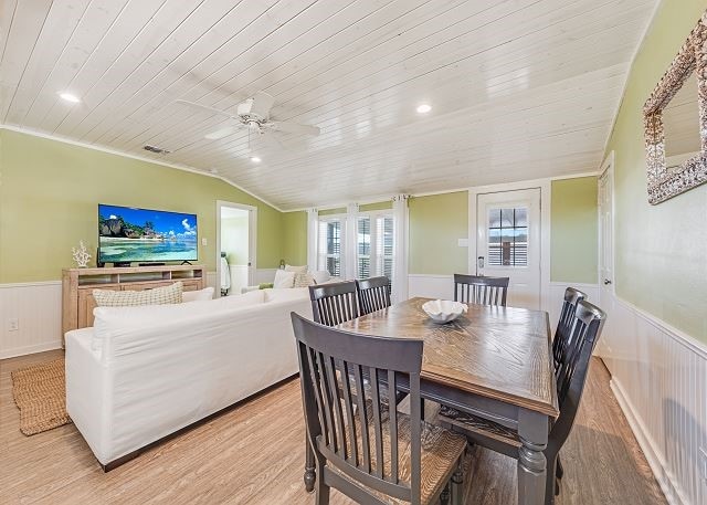 dining area with light wood-type flooring, vaulted ceiling, and wooden ceiling