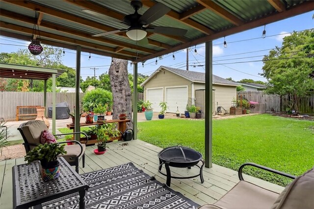 934 Cunningham St, Corpus Christi, TX 78411 - fenced backyard featuring a fire pit, a detached garage, an outbuilding, a deck, and a ceiling fan