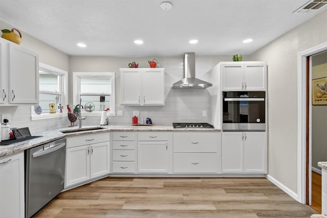 934 Cunningham St, Corpus Christi, TX 78411 - kitchen with stainless steel appliances, wall chimney range hood, tasteful backsplash, white cabinetry, and recessed lighting