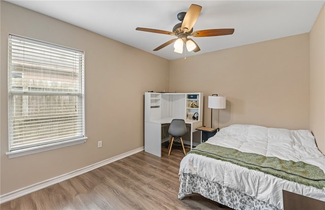 bedroom featuring wood finished floors, a ceiling fan, and baseboards