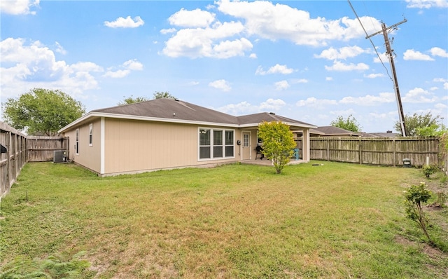 rear view of property with a patio area, a lawn, central AC, and a fenced backyard