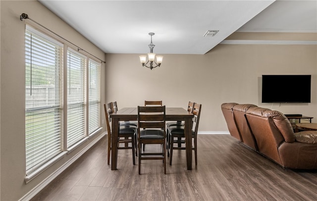 dining room with baseboards, visible vents, a notable chandelier, and dark wood finished floors